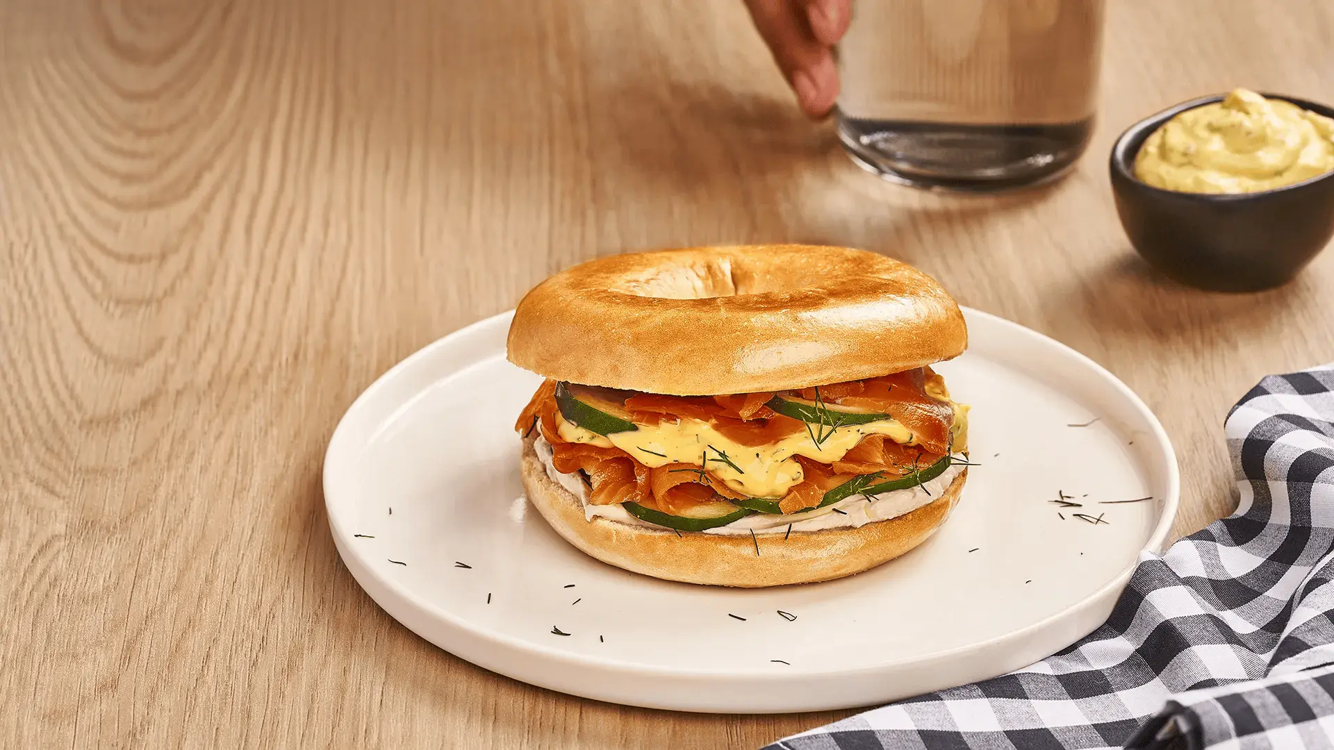 Bagel de salmón ahumado, queso crema, pepino y salsa de eneldo