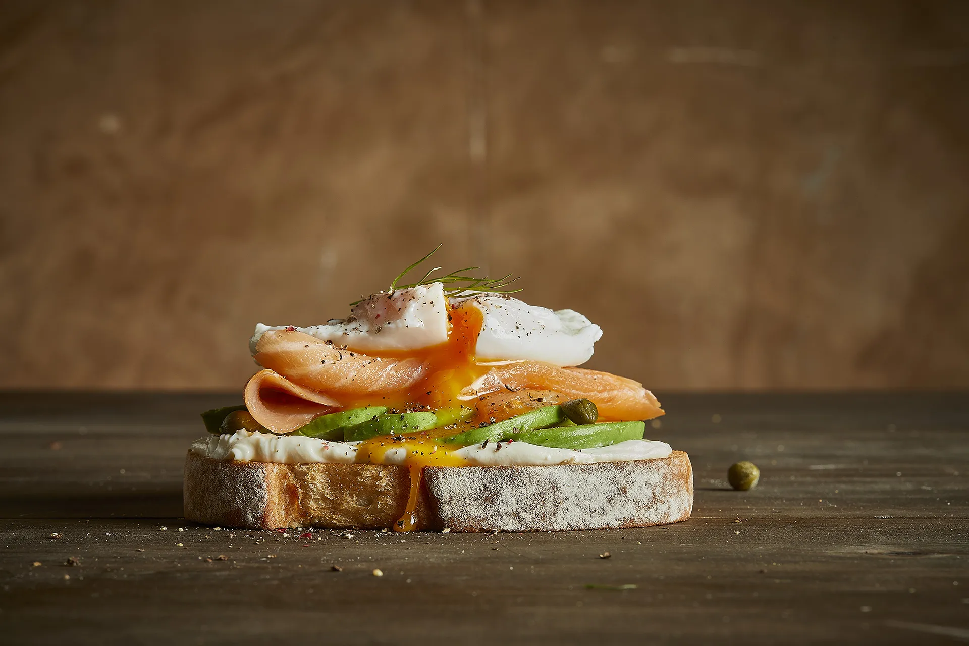 Tostada de salmón ahumado con queso de untar, aguacate y huevo poche