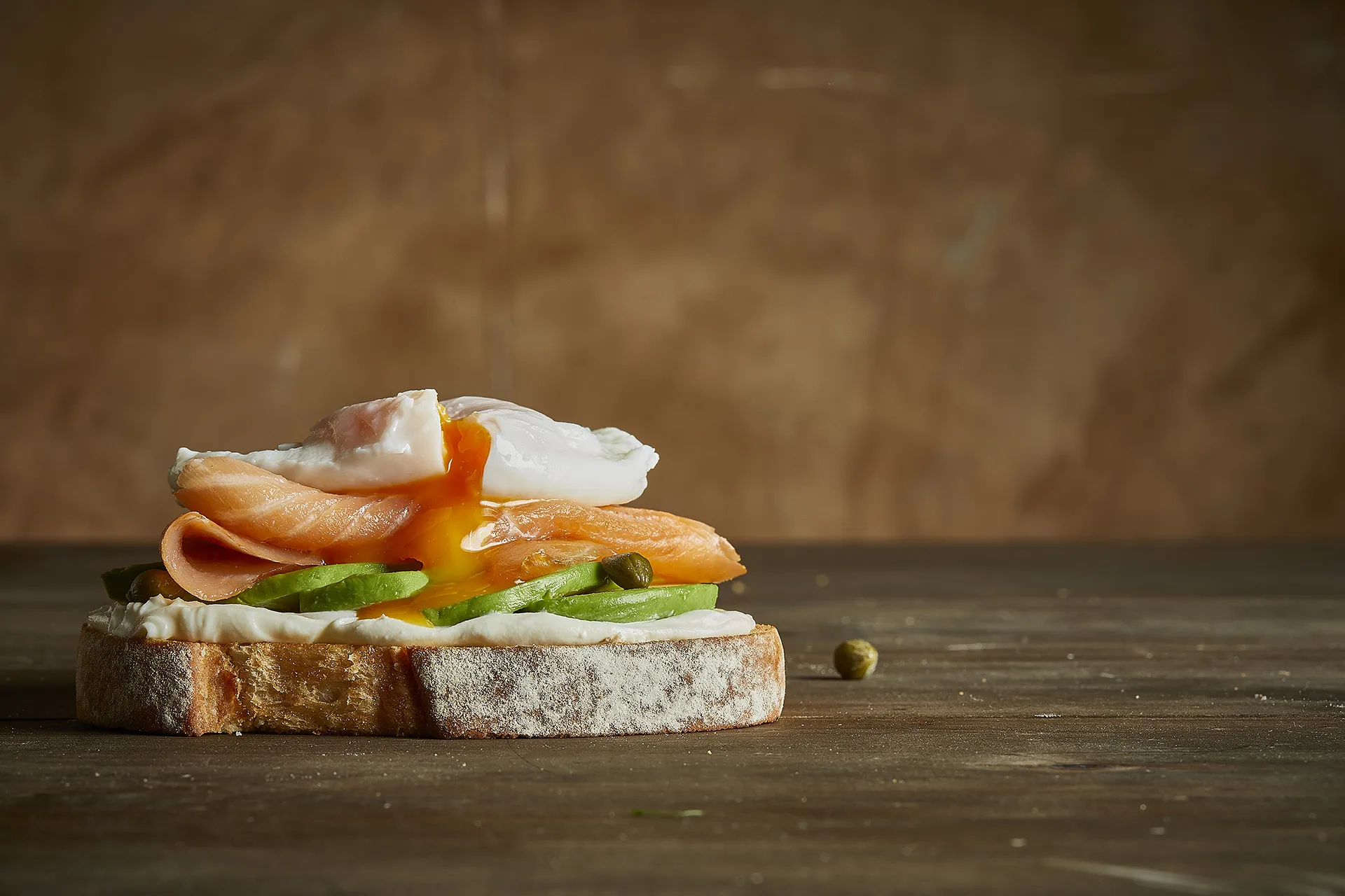 Tostada de salmón ahumado con queso de untar, aguacate y huevo poche